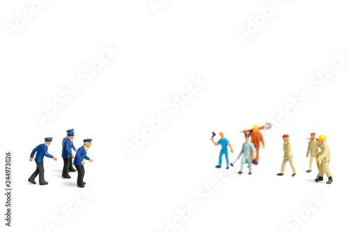 Miniature people : Police and an angry mob on white background