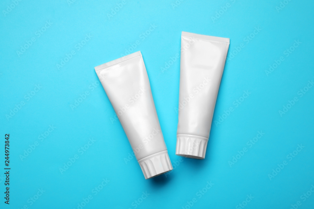 Blank tubes of toothpaste on color background, top view Blank tubes of toothpaste on color background, top view