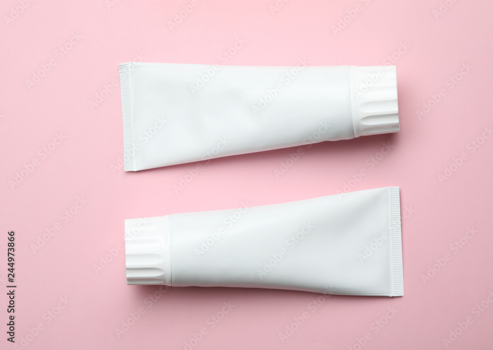 Blank tubes of toothpaste on color background, top view Blank tubes of toothpaste on color background, top view