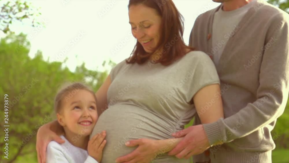 Happy family. Pregnant woman with her husband and little girl together outdoors. Father, mother and their little daughter. Healthy Pregnancy concept, parenthood. Slow motion 4K UHD video 3840x2160 Happy family. Pregnant woman with her husband and little girl together outdoors. Father, mother and their little daughter. Healthy Pregnancy concept, parenthood. Slow motion 4K UHD video 3840x2160