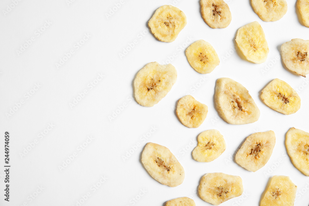 Flat lay composition with banana slices on white background, space for text. Dried fruit as healthy snack Flat lay composition with banana slices on white background, space for text. Dried fruit as healthy snack