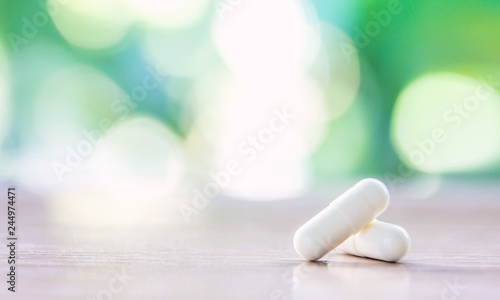 Obraz na płótnie white medicine capsule on wooden table with natural background