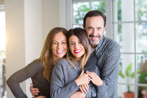 Beautiful family together. Mother, father and daughter smiling and hugging with love at home.