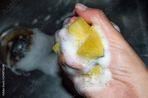 Hand removing the foam from a yellow and green dishwasher cleaner