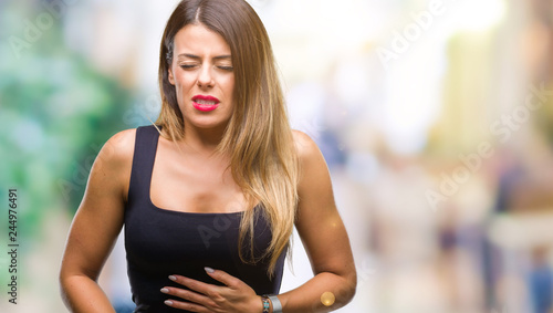 Young beautiful woman over isolated background with hand on stomach because indigestion, painful illness feeling unwell. Ache concept.
