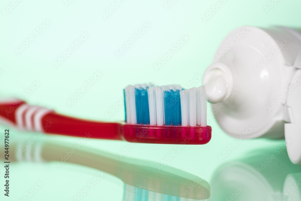 Toothpaste on a toothbrush on a white or colored background Toothpaste on a toothbrush on a white or colored background