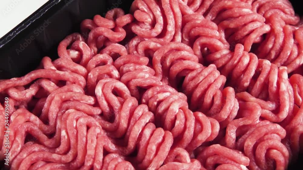Ground beef in black plastic container on white background rotates top view Ground beef in black plastic container on white background rotates top view