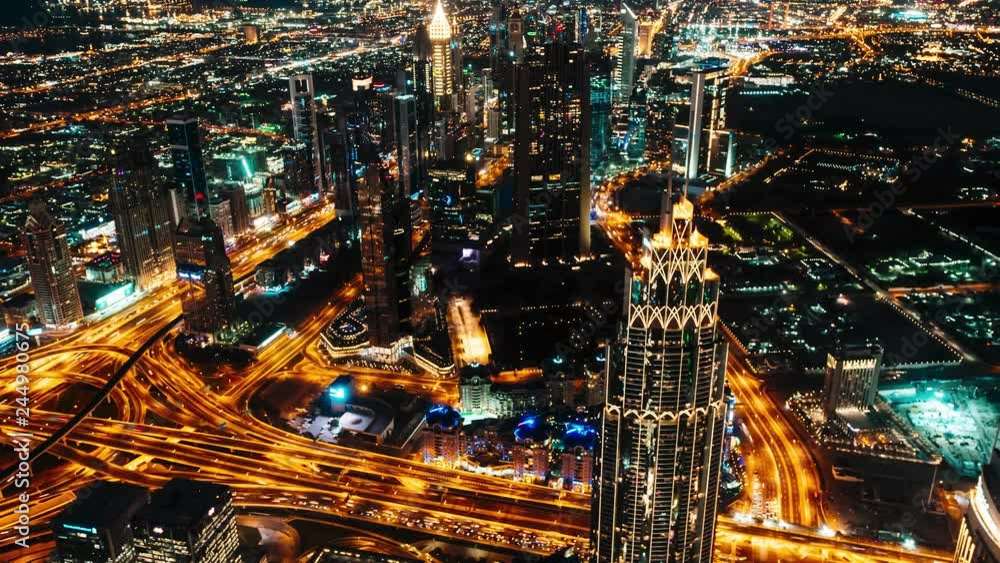 Breathtaking view from the height of a bird's flight to the night city of Dubai, UAE. Numerous night lights and illuminations, well-lit traffic intersection and adjacent motorways. Ultra modern Breathtaking view from the height of a bird's flight to the night city of Dubai, UAE. Numerous night lights and illuminations, well-lit traffic intersection and adjacent motorways. Ultra modern