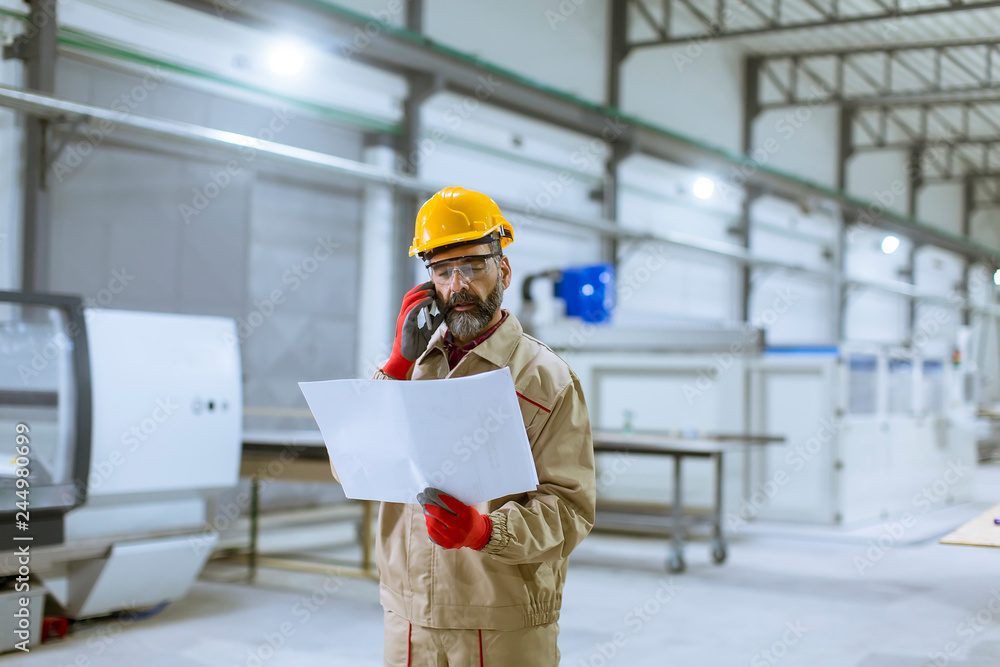 Engineer looking at plan in the factory Engineer looking at plan in the factory