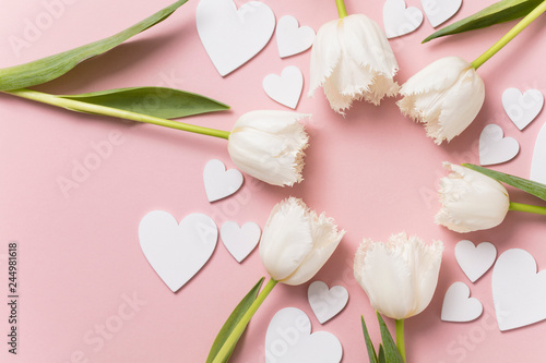 White flowers and hearts on a pastel pink background