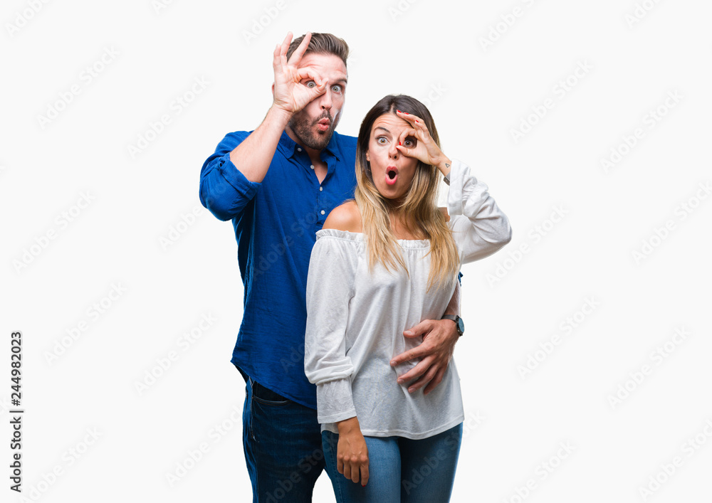 Young couple in love over isolated background doing ok gesture shocked with surprised face, eye looking through fingers. Unbelieving expression. Young couple in love over isolated background doing ok gesture shocked with surprised face, eye looking through fingers. Unbelieving expression.