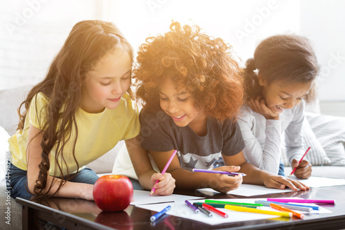 фотографія Multiethnic girls drawing at table with colorful pencils