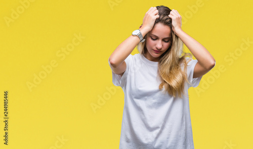 Young beautiful blonde woman wearing casual white t-shirt over isolated background suffering from headache desperate and stressed because pain and migraine. Hands on head.