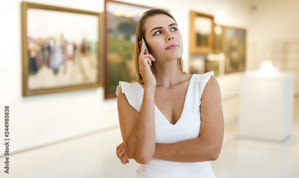 Woman talking by phone in museum