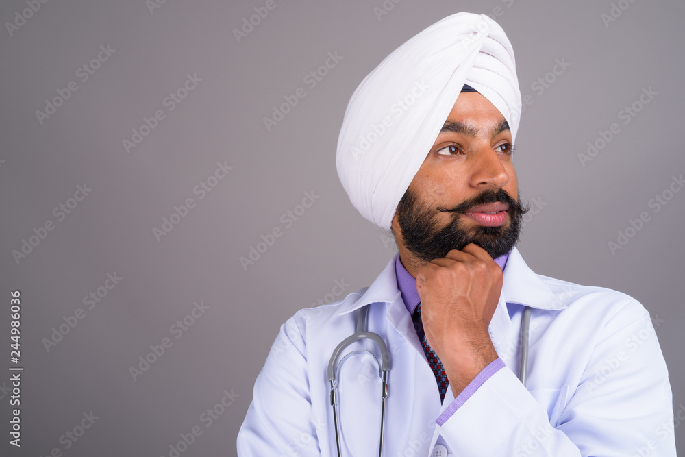 Portrait of young Indian Sikh man doctor thinking Portrait of young Indian Sikh man doctor thinking