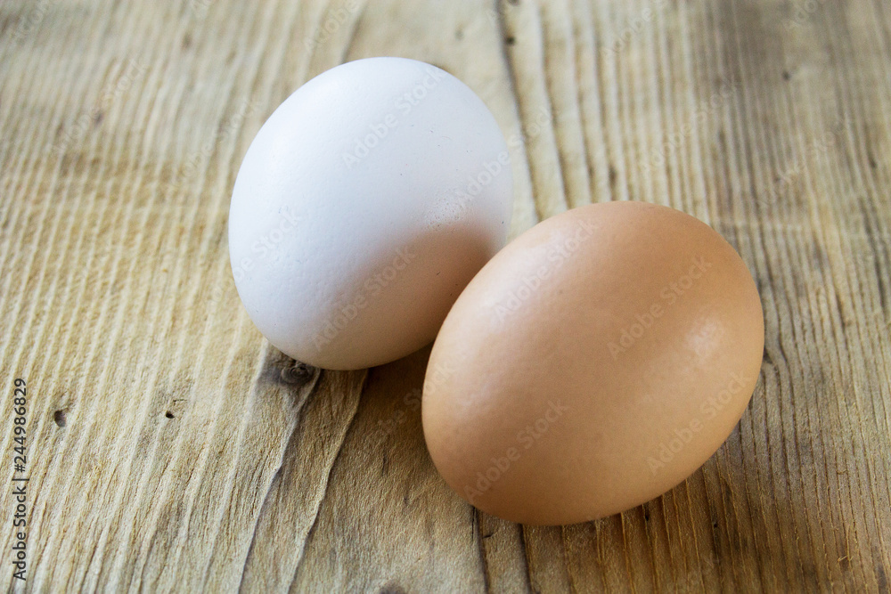 white and brown egg on a wooden board white and brown egg on a wooden board