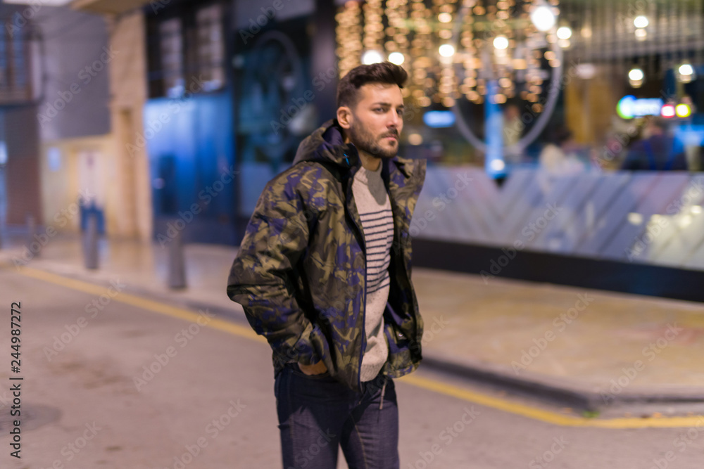 Young handsome man possing and smiling. Street style at night Young handsome man possing and smiling. Street style at night