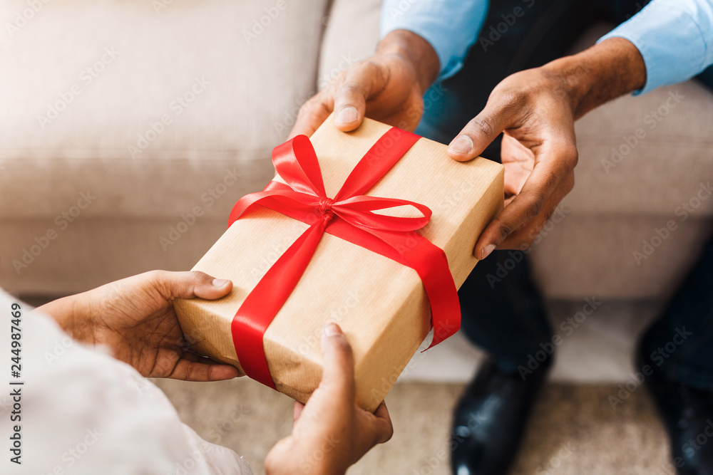 Father hands giving birthday gift to daughter Father hands giving birthday gift to daughter