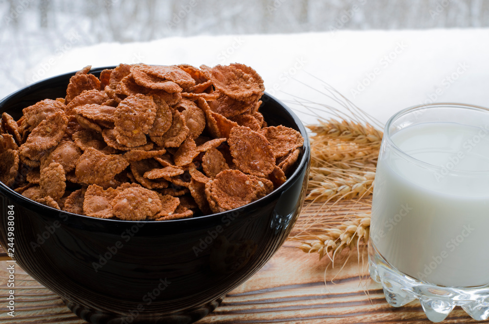 A healthy breakfast. Cereals are at the black plate on the wood background A healthy breakfast. Cereals are at the black plate on the wood background