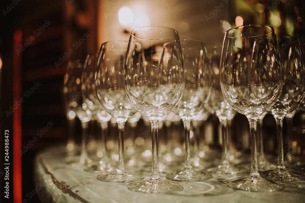 Line up of empty wine glasses on the bar. Restaurant, hospitality, catering and bar concept.