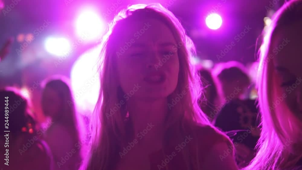 girlfriends dancing in a crowd of people at a concert in a dance club girlfriends dancing in a crowd of people at a concert in a dance club
