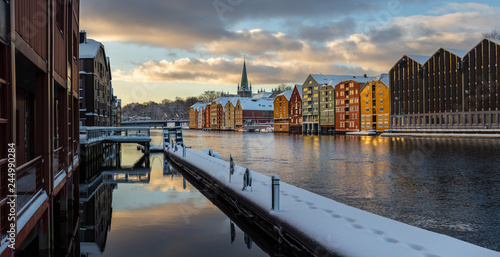 Old houses and magazines by Nidelva river in Trondheim, Nidarosdomen Cathedral in back.
