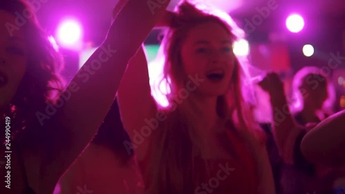 young girl dancing with her friends at a concert in a dance club