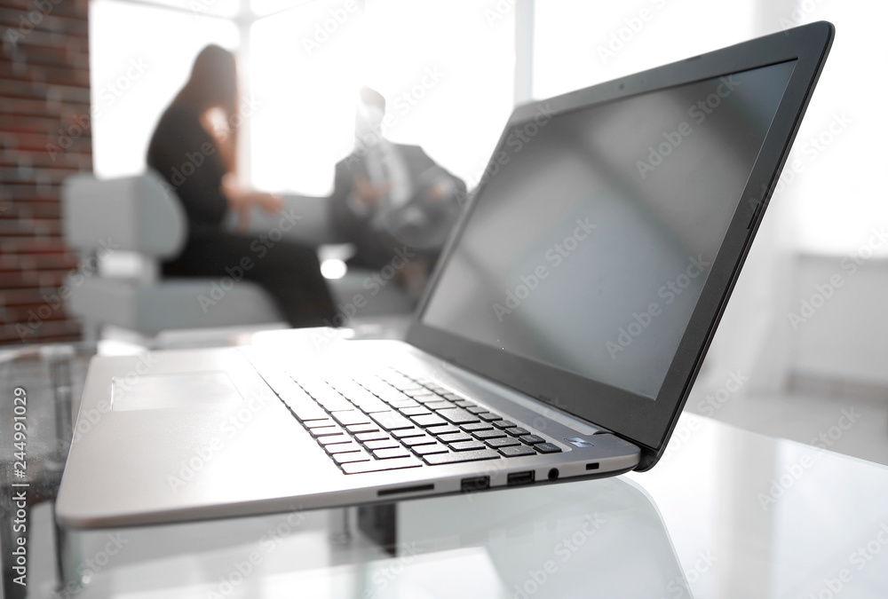 Focus on laptop on the table. Blurred people on background. Focus on laptop on the table. Blurred people on background.