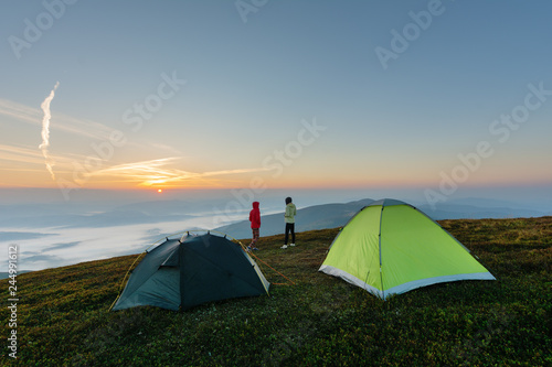 Fototapeta Naklejka Na Ścianę i Meble -  Girls on a mountain ridge rest with tents.