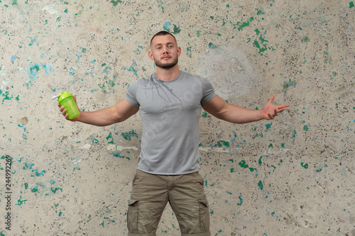 Obraz na plátne A attractive young guy is drinking water after a workout