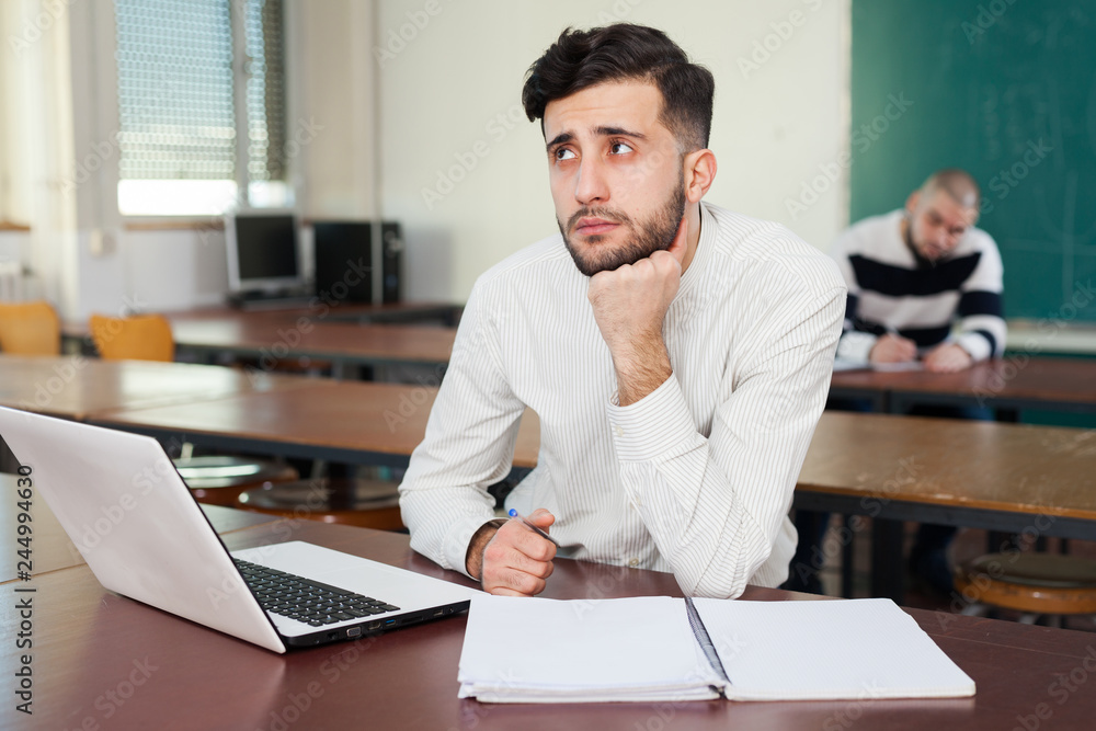 Naklejka premium Young guy studying with laptop