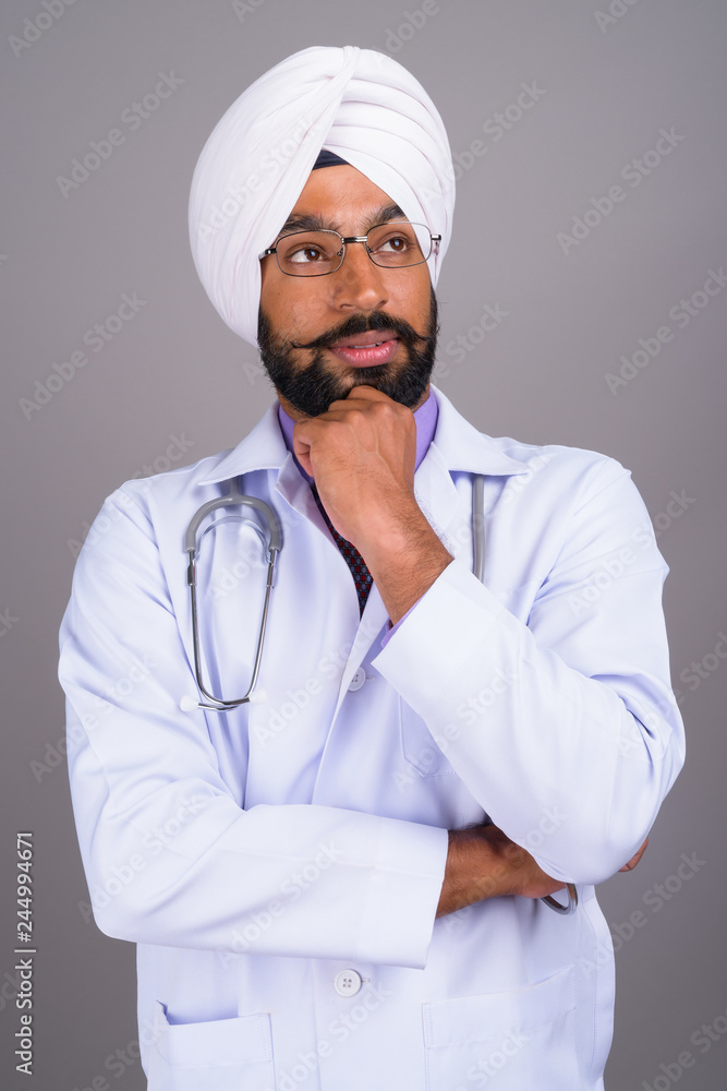 Portrait of young Indian Sikh man doctor thinking