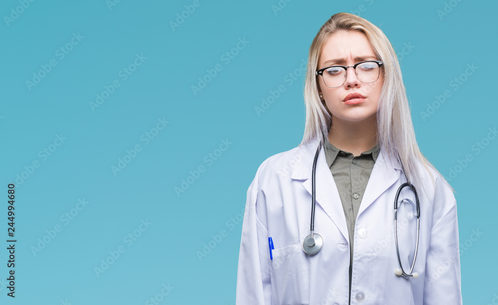 Young blonde doctor woman over isolated background skeptic and nervous, frowning upset because of problem. Negative person. Young blonde doctor woman over isolated background skeptic and nervous, frowning upset because of problem. Negative person.