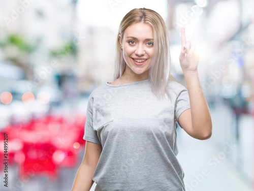 Young blonde woman over isolated background pointing finger up with successful idea. Exited and happy. Number one.