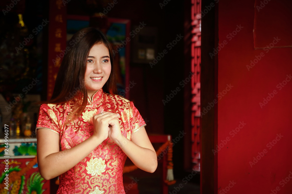 Woman wearing Chinese red dress Standing in front of the shrine, Happy New Year Woman wearing Chinese red dress Standing in front of the shrine, Happy New Year