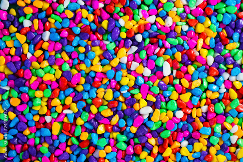 Multi-colored painted sea pebbles. Bright background.
