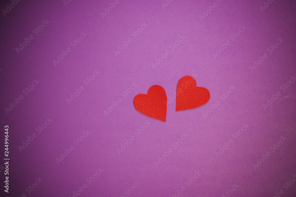Two red decorative hearts on purple background. Valentine's Day Concept.