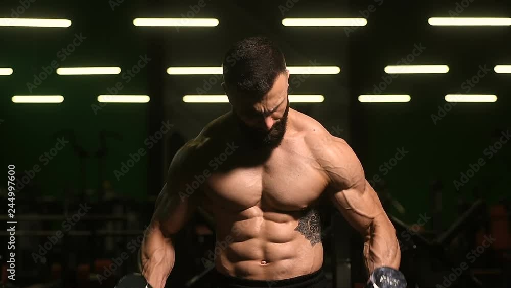 Handsome strong athletic men pumping up biceps muscles workout fitness and bodybuilding concept background - muscular bodybuilder fitness men doing arms exercises in gym naked torso slow motion Handsome strong athletic men pumping up biceps muscles workout fitness and bodybuilding concept background - muscular bodybuilder fitness men doing arms exercises in gym naked torso slow motion