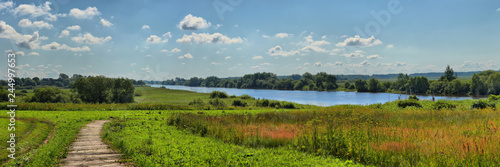 Summer panorama with a river and a wooden path