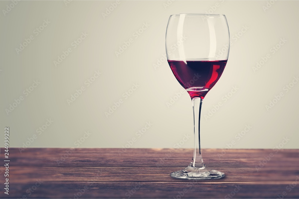 Red wine glass on wooden desk