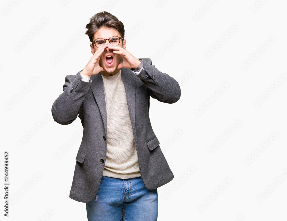 Young business man wearing glasses over isolated background Shouting angry out loud with hands over mouth Young business man wearing glasses over isolated background Shouting angry out loud with hands over mouth