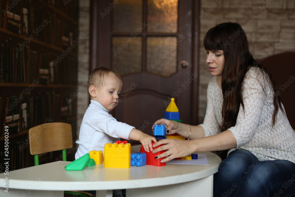 Toddler with mother plays with plastic constructor Toddler with mother plays with plastic constructor