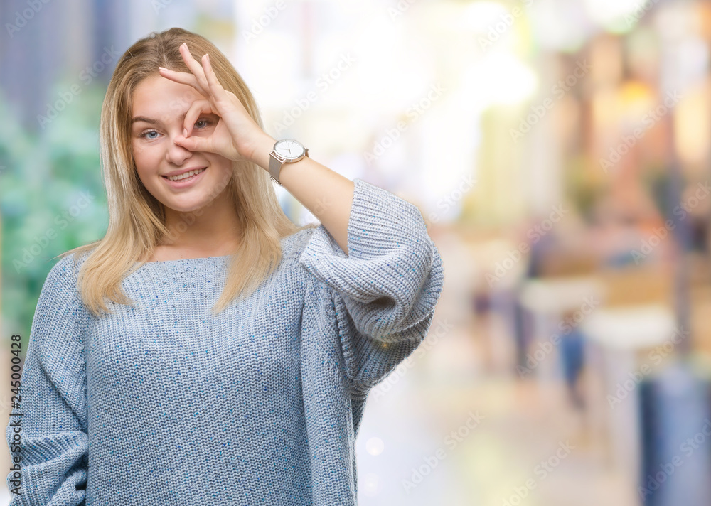 Young caucasian woman wearing winter sweater over isolated background doing ok gesture with hand smiling, eye looking through fingers with happy face.