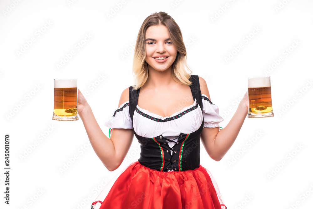 Young sexy woman wearing a dirndl with two beer mugs over white background Young sexy woman wearing a dirndl with two beer mugs over white background