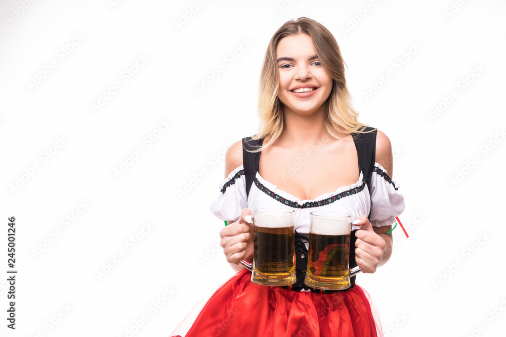 Young sexy woman wearing a dirndl with two beer mugs over white background Young sexy woman wearing a dirndl with two beer mugs over white background
