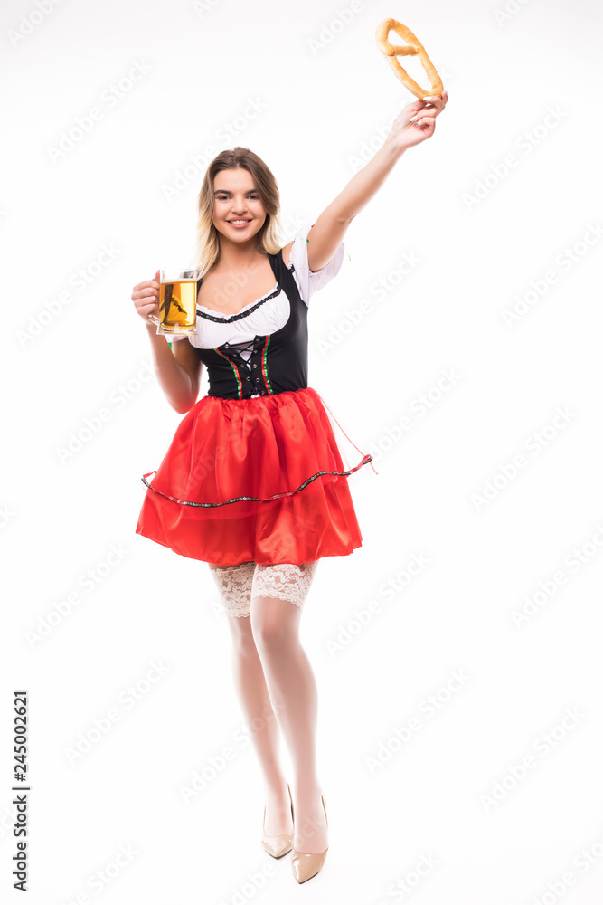 Young Oktoberfest woman wearing a traditional Bavarian dress dirndl posing with a pretzel and beer mug in hands on white background. Young Oktoberfest woman wearing a traditional Bavarian dress dirndl posing with a pretzel and beer mug in hands on white background.
