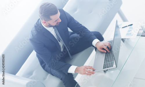 Top view businessman working on laptop with financial graphs photo