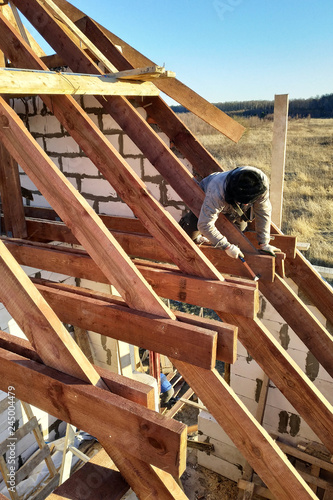 Layout and installation of roof rafters on a new commercial residential construction project by framing contractors