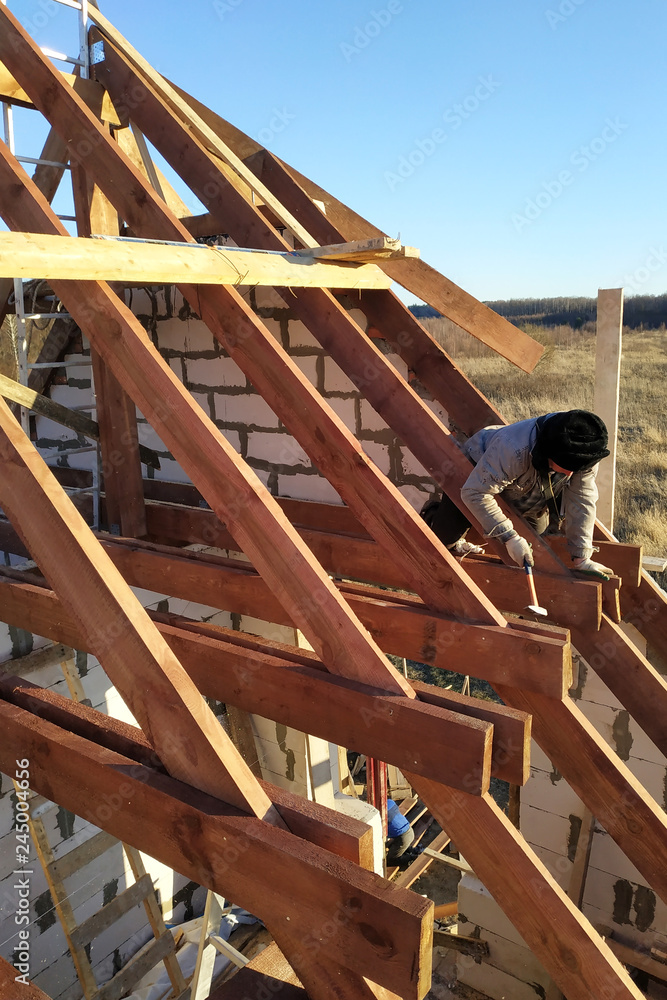 Layout and installation of roof rafters on a new commercial residential construction project by framing contractors
