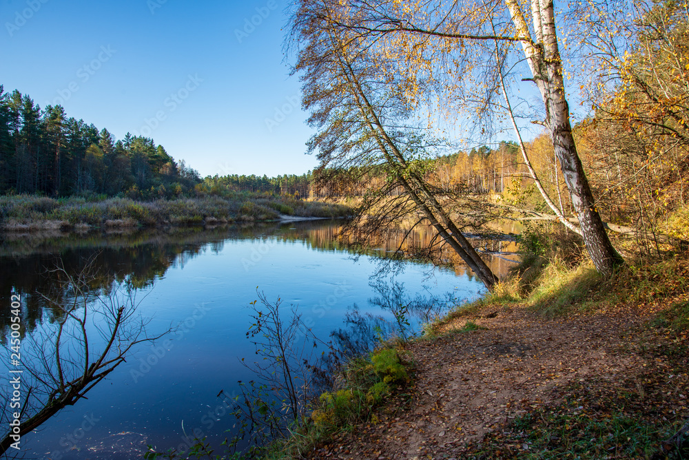 blue sky and clouds reflecting in calm water of river Gauja in latvia in autumn